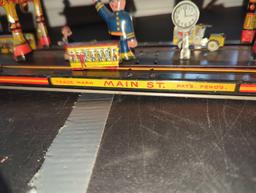 (LR) WIND UP TIN TOY, MAIN STREET, THE TURN KEY WORKS HOWEVER THE STRING THAT OPERATES THE ACTION OF