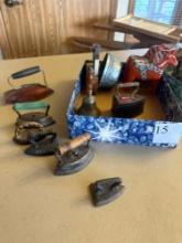 Various kinds and sizes of sad irons, school bell, etc.