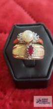 Gold colored ring with red and clear gemstones, marked 12K GE ESPO. Gold colored ring with pearl