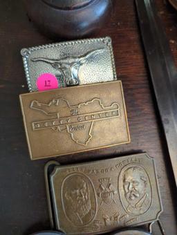 (FD) LOT OF 5 BELT BUCKLES. TIFFANY AND CO WELLS FARGO CO, HIT LINE USA, BULL, AND THE GETTY CENTER